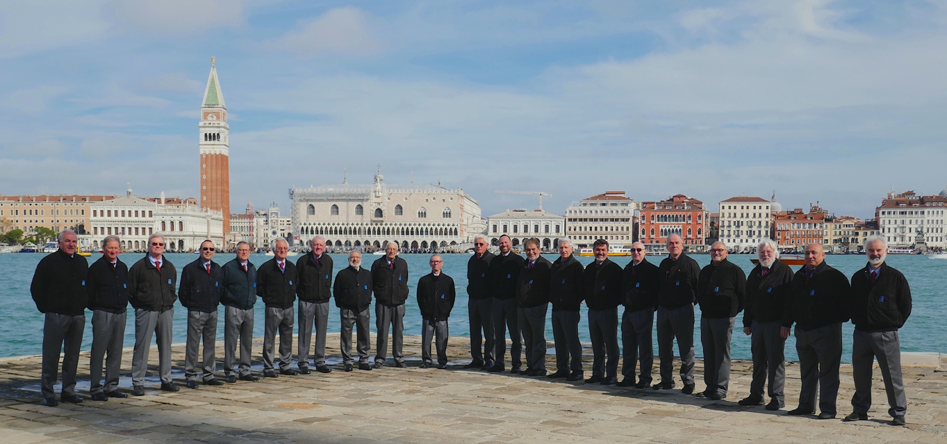 21 membri di un coro in posa in riga di fronte al bacino di San Marco