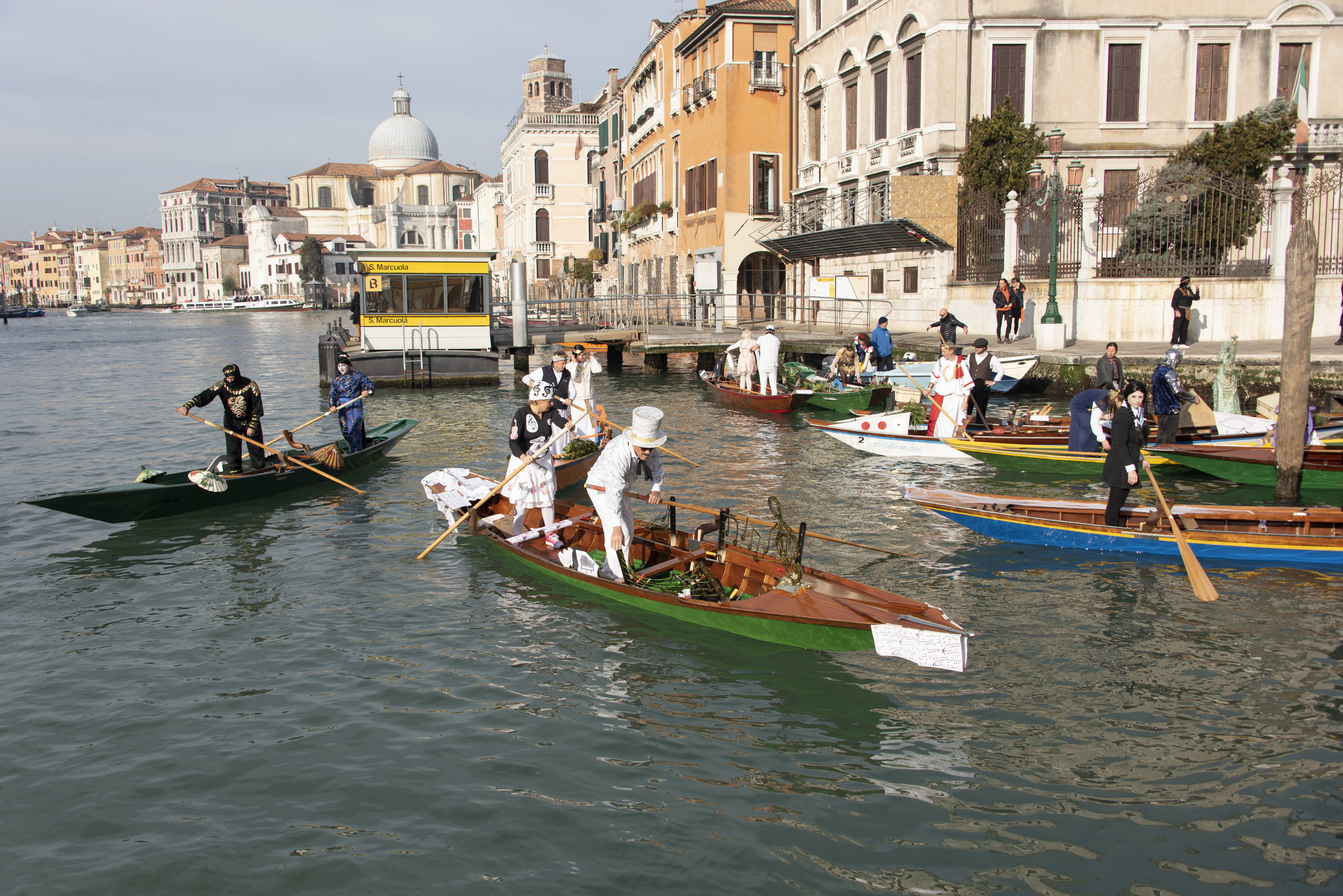 Vogatori in maschera su imbarcazioni nel Canal Grande di Venezia