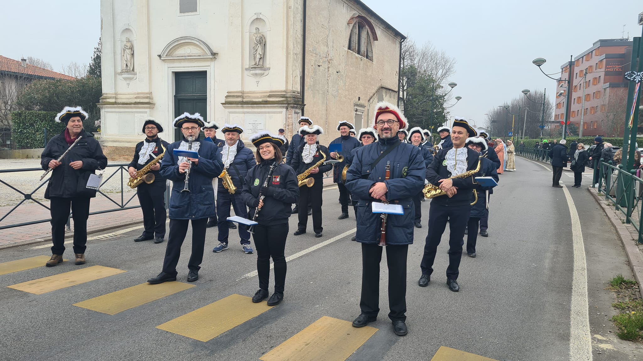 Banda musicale in posa sulla strada, davanti a una chiesa