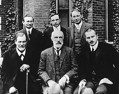  in foto da sinistra a destra: Sigmund Freud, Stanley Hall, C.G.Jung. Fila dietro, da sinistra a destra: Abraham A. Brill, Ernes