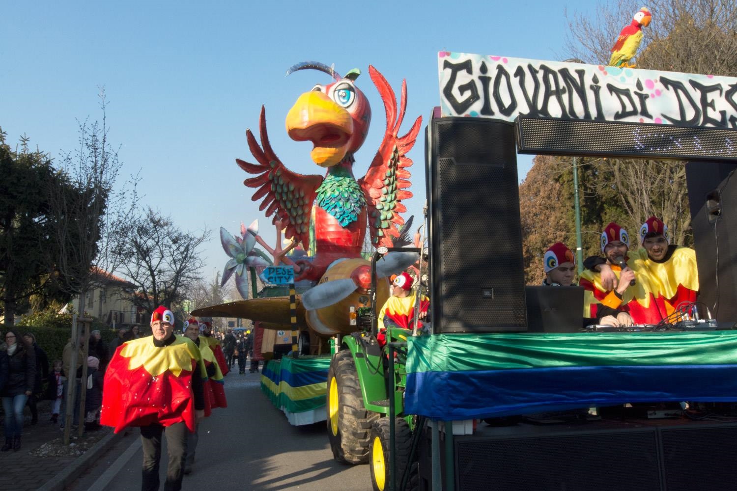 Sfilata di Carnevale con in primo piano un carro allegorico con un enorme pappagallo