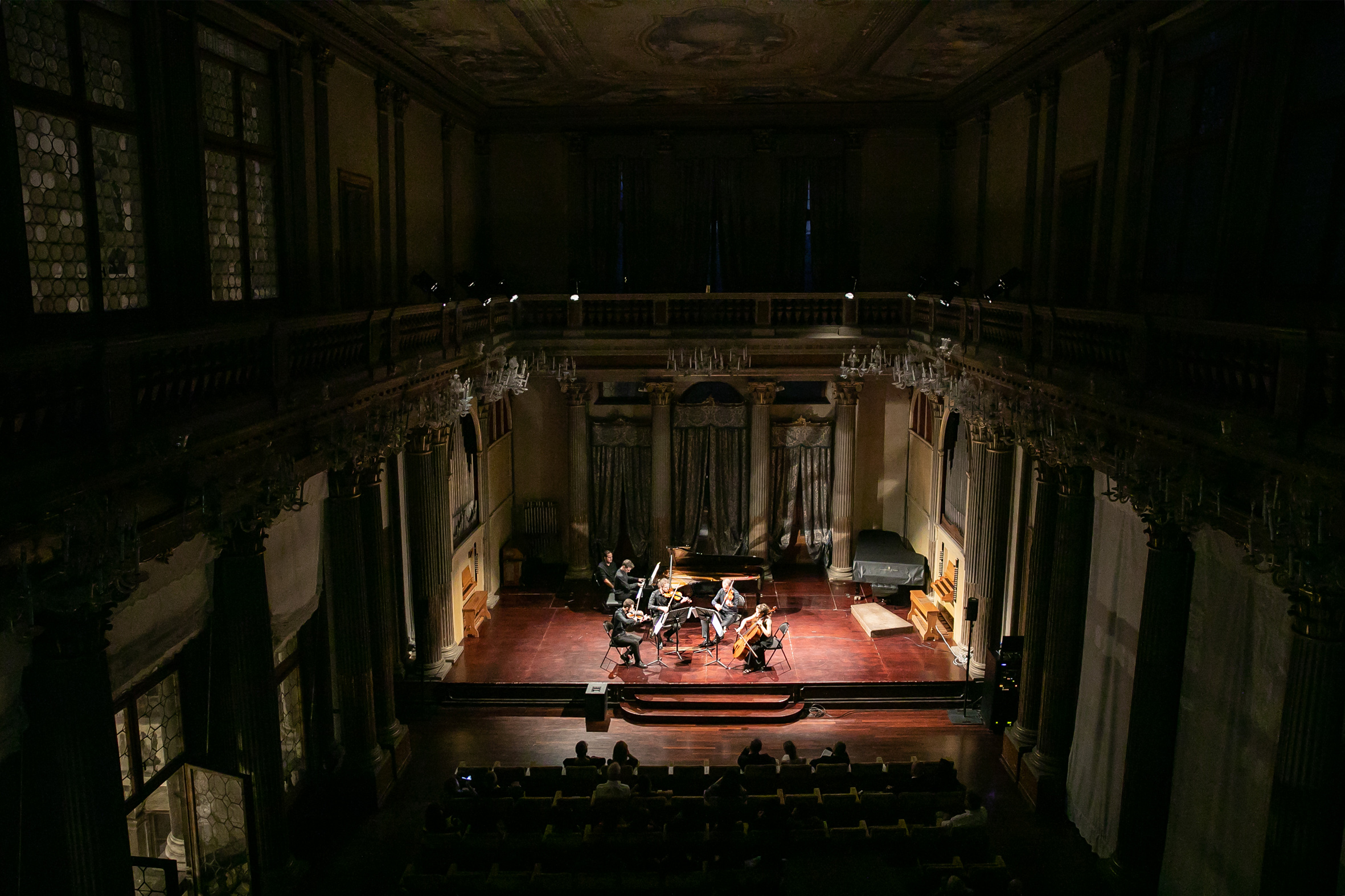 Sei musicisti sul palco, visti dal punto di vista della galleria