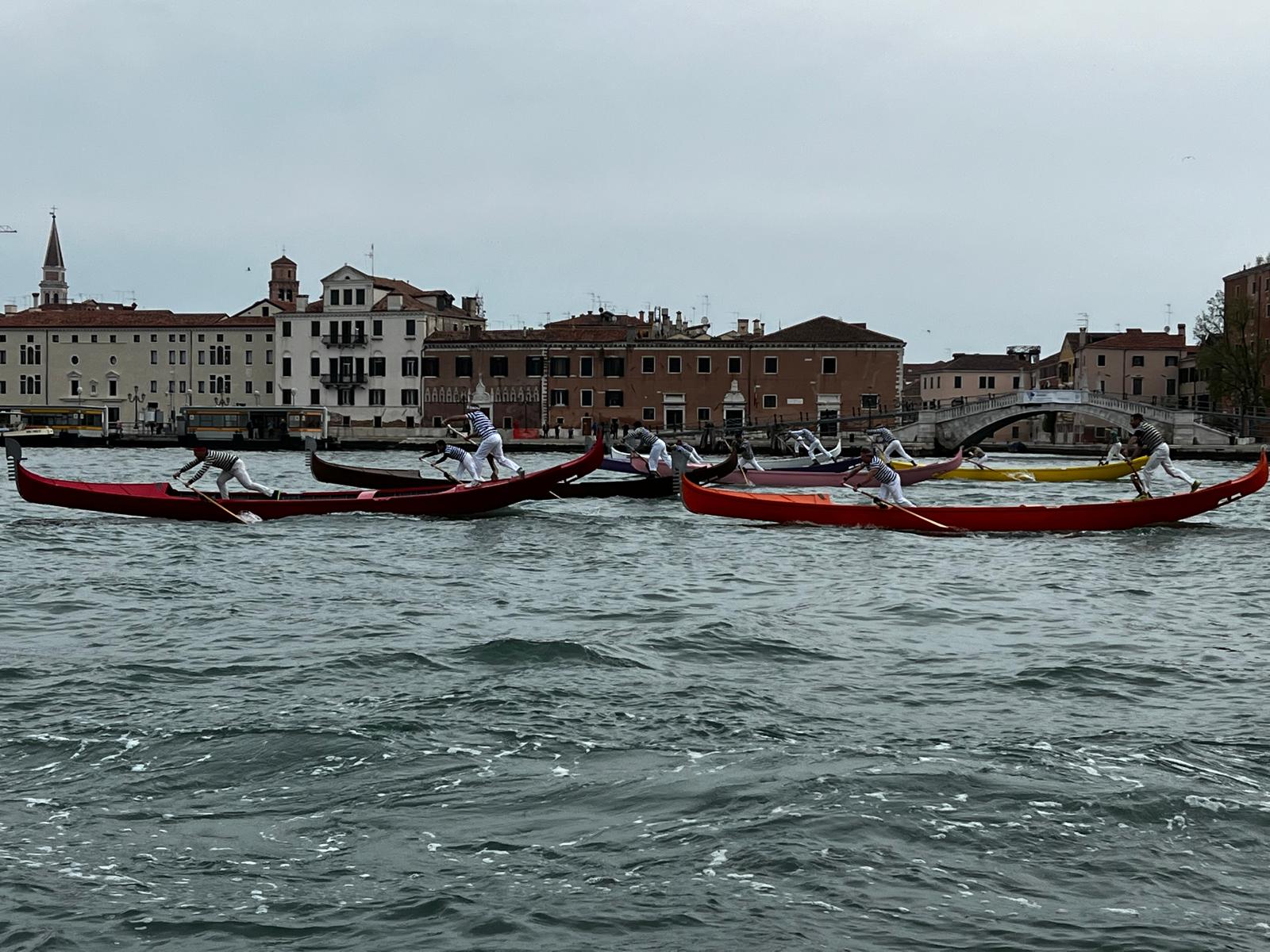 Gondole a quattro remi in durante una regata su un canale di Venezia