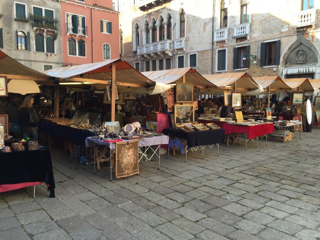 Cinque banchi da mercato coperti disposti in un campo veneziano