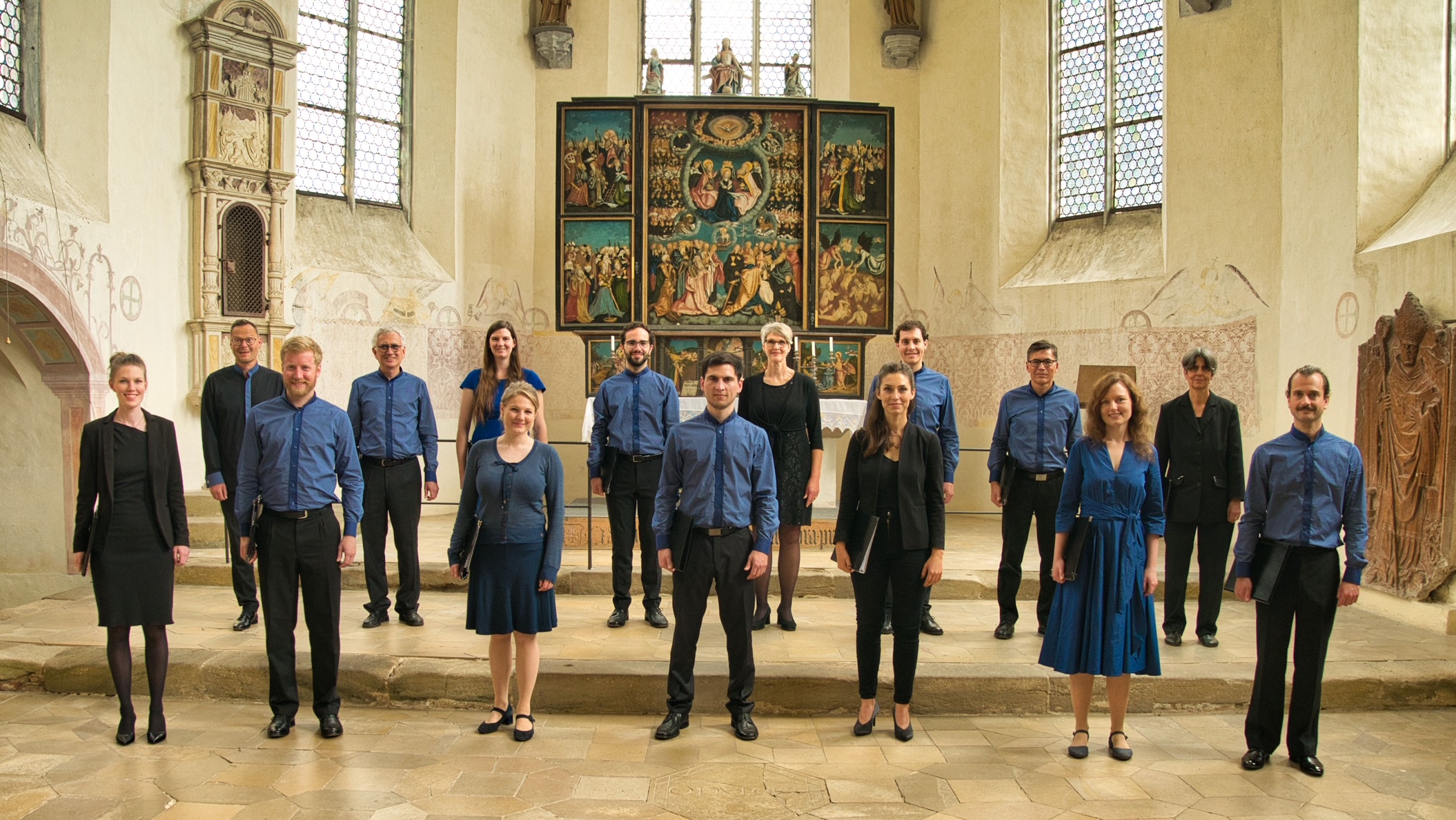 Ensemble musicale di 15 persone in posa in abside di una chiesa