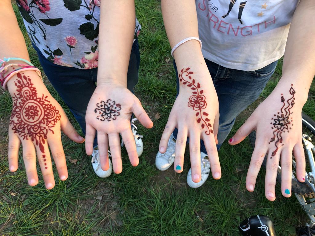 Particolare di quattro mani decorate con l'henné
