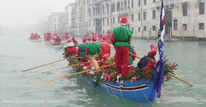 barca sul Canal Grande a Venezia vista da dietro, con equipaggio in costume da Babbo Natale